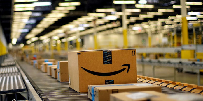 Des paquets Amazon se déplacent sur un tapis roulant dans un entrepôt de stockage